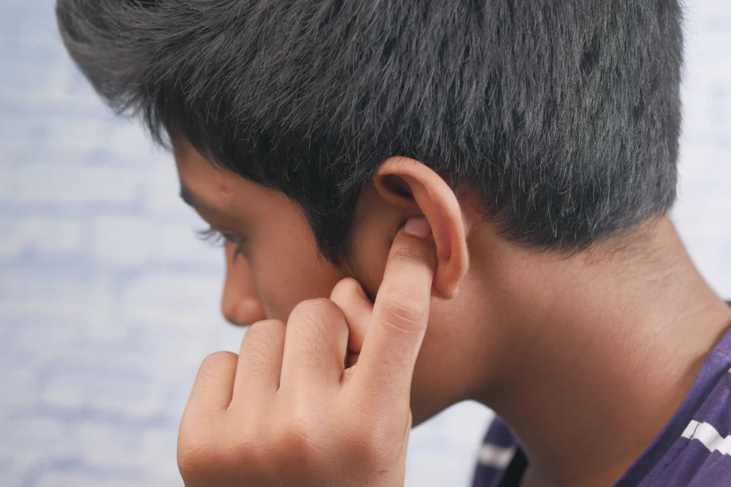 jeune garçon qui a l'oreille bouchée