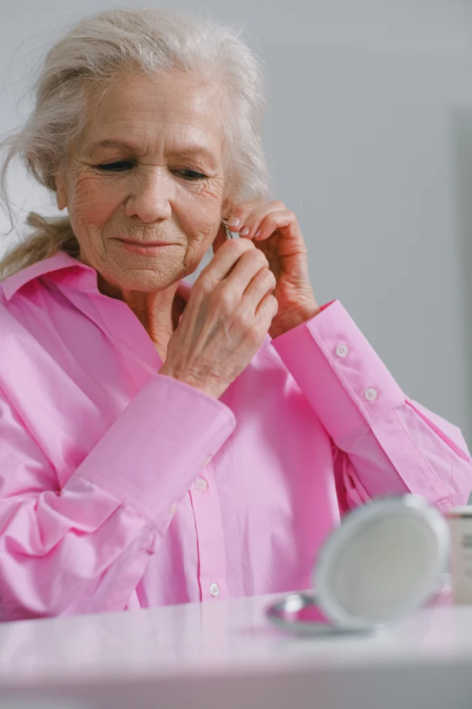 femme âgée qui met des boucles d'oreilles