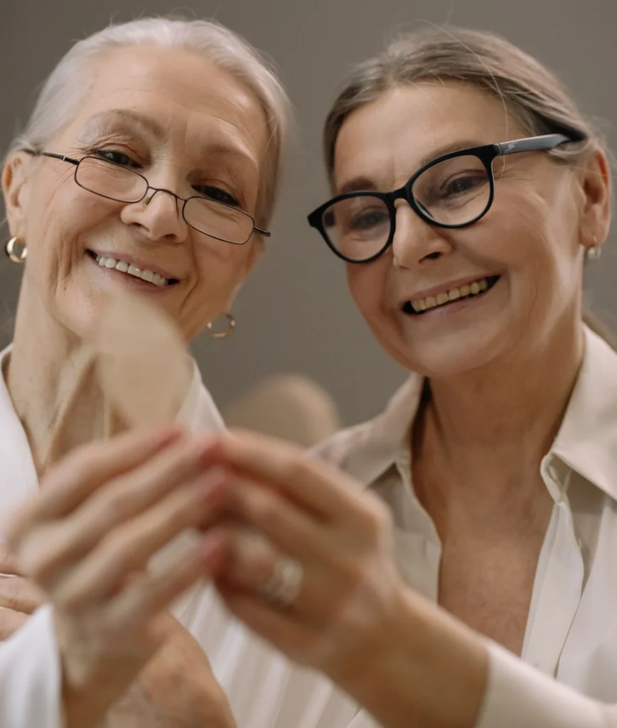 deux femmes regardent une audioprothèse en souriant